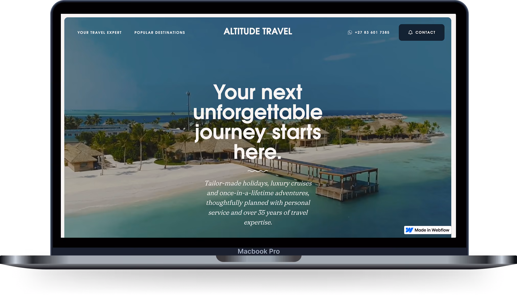 Laptop screen showing a travel website with a tropical island beach and pier in turquoise water.