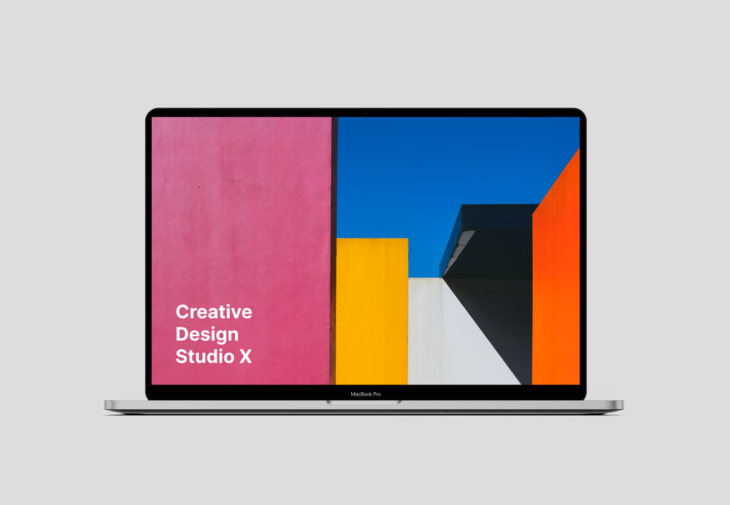 MacBook Pro displaying colorful modern architecture with text 'Creative Design Studio X' on pink wall.